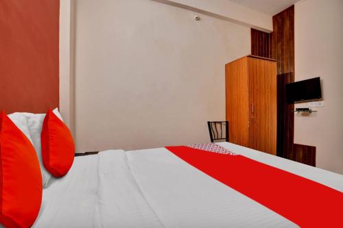 a bedroom with a bed with red pillows at Hotel O Sudipti Resort in Indore