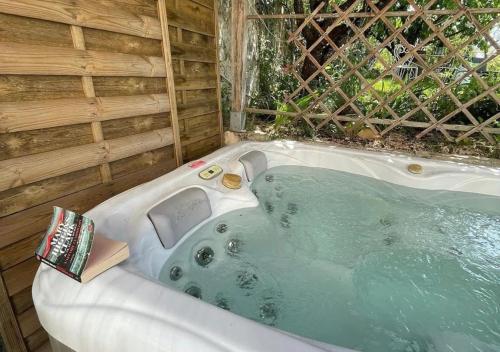 a jacuzzi tub with a book sitting in it at Relais Golf et Champagne in Villers-Agron-Aiguizy