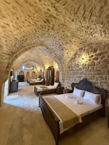 a bedroom with two beds in a stone room at Rocinante House in Mardin