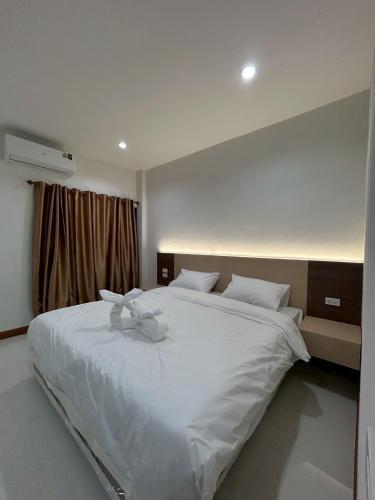 a bedroom with a large white bed with white sheets at โรงแรมเมืองเลยริเวอร์วิว in Ban Tha Phae