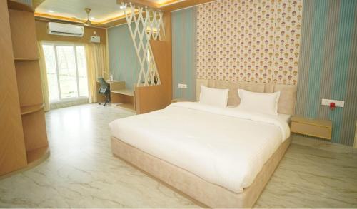 a bedroom with a large white bed in a room at Siddharaj Resort in Mal bazar