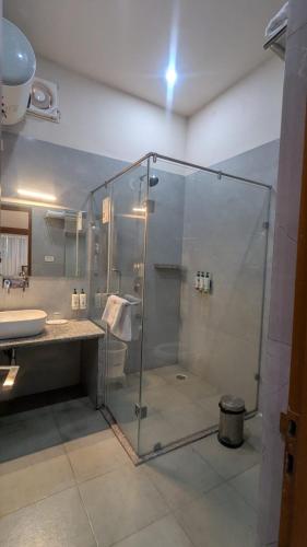 a bathroom with a glass shower and a sink at Bamboo Saa Sunrrise Wedding & Wellness Resort, Jaipur in Jaipur