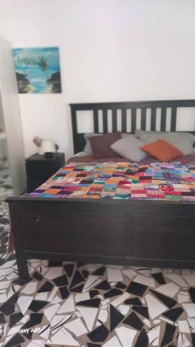 a bed with a quilt on it in a bedroom at Arijaana Guesthouse in Gunjur
