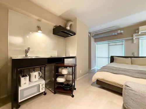 a bedroom with a bed and a sink in it at Origaminn 301 by b hotel - 5 mins Peace Park in Hiroshima