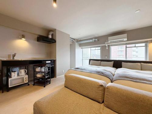a living room with two beds and a couch at Origaminn 401 by b hotel - 5 mins Peace Park in Hiroshima
