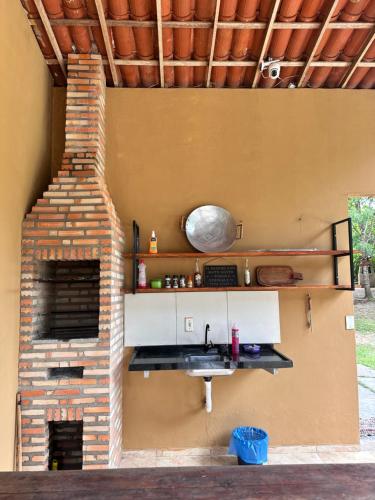 a kitchen with a brick fireplace in a house at Chalé Canto dos Pássaros in Viçosa do Ceará