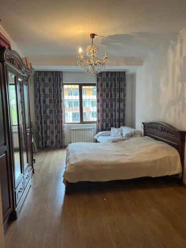 a bedroom with two beds and a chandelier at Big Flat in Tbilisi City