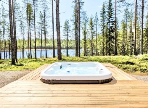 a bath tub sitting on top of a wooden deck at Spa Cabin by Hossaville in Hossa
