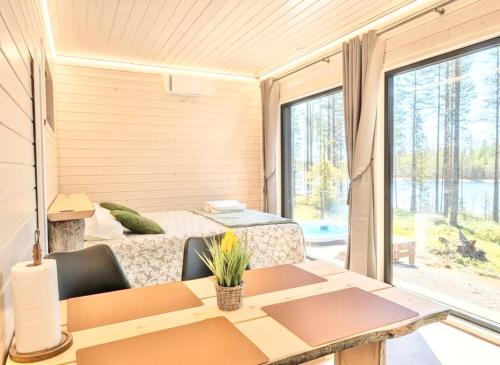 a room with a table and a bed and a window at Spa Cabin by Hossaville in Hossa