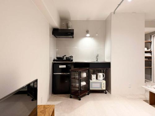 a kitchen with a black counter and a microwave at Origaminn 602 by b hotel - 5 mins PeacePark in Hiroshima