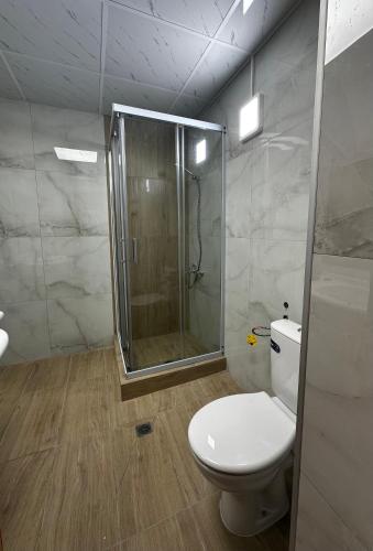 a bathroom with a shower and a white toilet at Hotel RIVA in Golden Sands