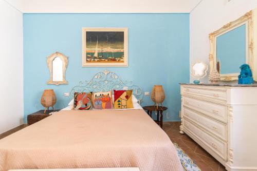 una camera da letto blu con un letto e una cassettiera di A' BITTA a Favignana