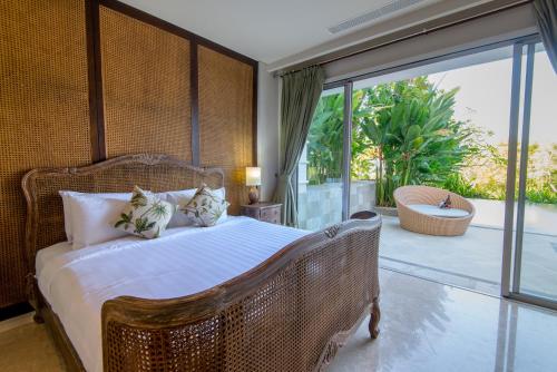a bedroom with a large bed and a balcony at Luxury Apartment at AYANA Residences in Jimbaran