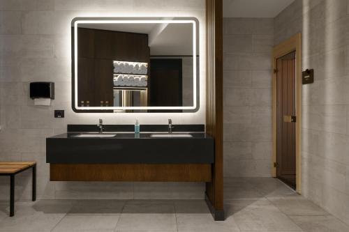 a bathroom with a sink and a mirror at Novotel Tbilisi Center in Tbilisi City