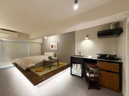 a bedroom with a bed and a sink in it at Origaminn 503 by b hotel - 5 mins PeacePark in Hiroshima