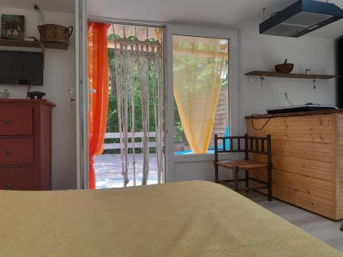a bedroom with a bed and a sliding glass door at studio dans les arbres in Saint-Paulet-de-Caisson