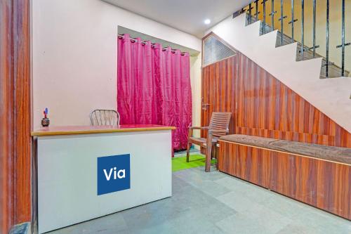 a room with a desk and a staircase with pink curtains at Via Shree Gopal Inn in Varanasi