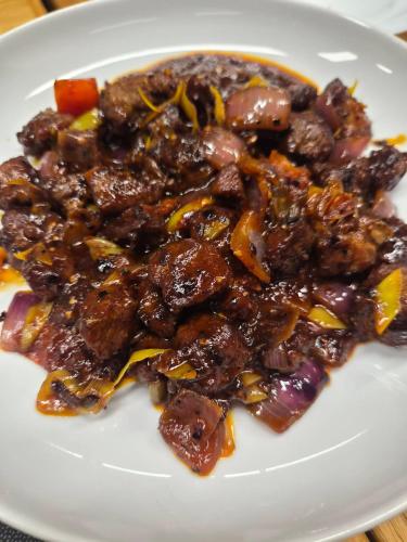 a white plate of food with meat and vegetables at Benthota grand villa in Nakandalagoda