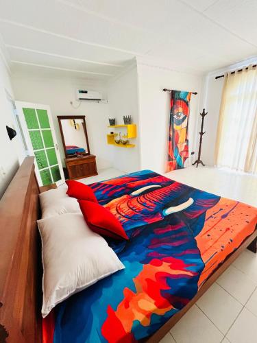 a bedroom with a bed with a colorful comforter at Benthota grand villa in Nakandalagoda