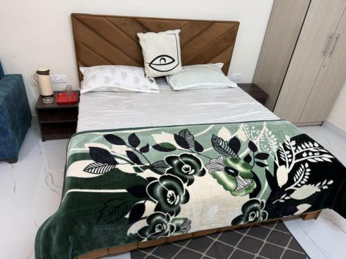 a bed with a green and white blanket on it at Sundervan Resort in Alwar