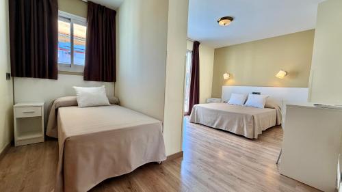 a room with two beds and a window at Hotel Celymar in Benidorm