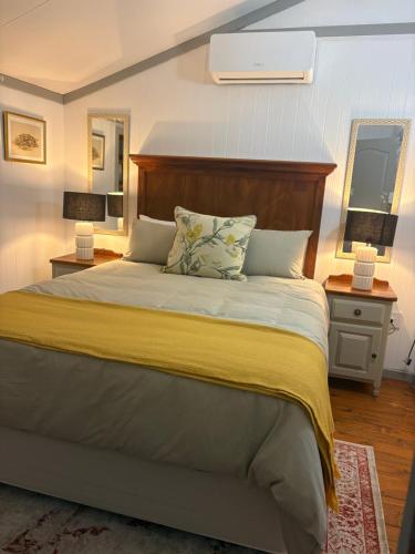a bedroom with a large bed with a yellow blanket at The Cabin at Skyfall Country Estate in Polokwane