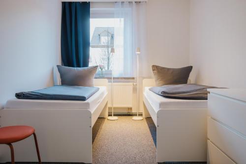 two beds in a room with a window at Monteurwohnung Spremberg in Spremberg