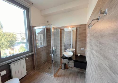 a bathroom with a glass shower and a sink at Casa Makeda in Rosate
