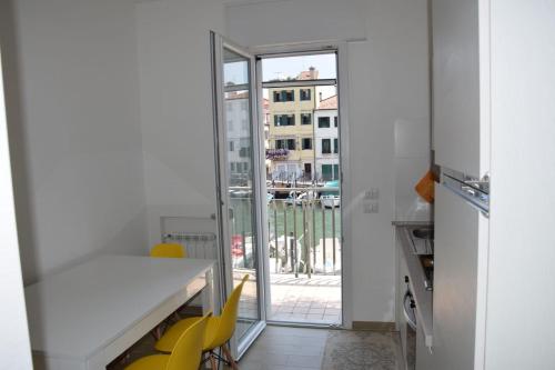 a kitchen with yellow chairs and a table and a window at el Capitan de Mar in Chioggia