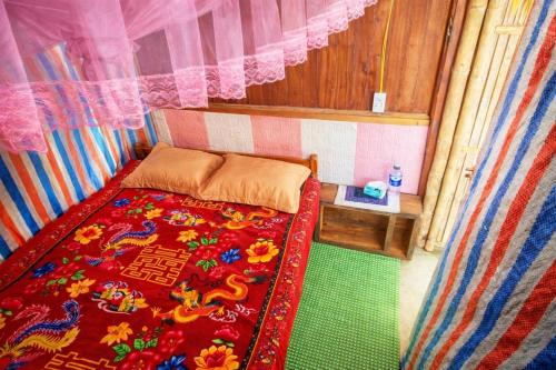 a small bedroom with a bed with a colorful bedspread at Mama Pham Homestay in Tả Van
