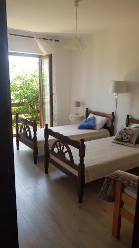 a bedroom with two beds and a large window at Villa Letina in Sukošan