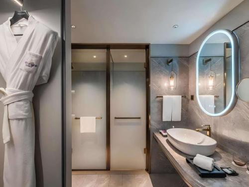 a bathroom with a sink and a mirror at Mercure Wuhan Yangluo in Wuhan