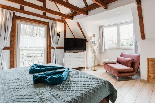 a bedroom with a bed and a tv and a chair at HarzZeitRaum in Thale