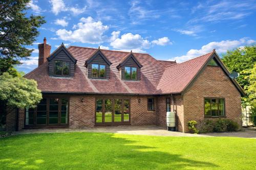 a brick house with a red roof at Serene Retreat - Hot Tub - Pool Table - Close to New Forest and Bournemouth Beach - Sleeps 12 in Hurn