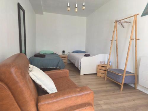 a living room with a couch and two beds at Le Little cocoon in Durtol