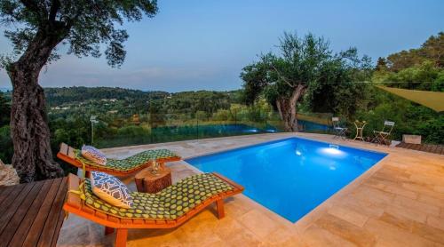 a swimming pool with two chairs and a table at Lucié in Argyrátika