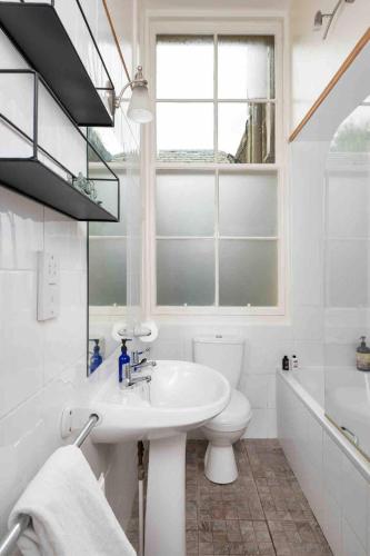 a bathroom with a sink and a toilet and a window at Garden Flat- Private Luxury in Ashkirk