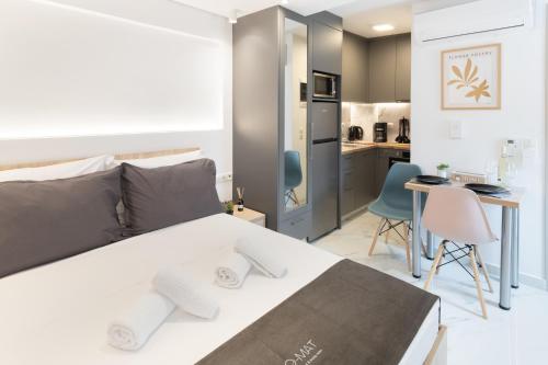 ein Schlafzimmer mit einem weißen Bett und eine Küche in der Unterkunft Anassa Suites 3 in Iraklio