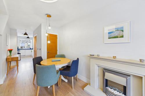 a dining room with a table and a fireplace at Luxury 3-Bed house, Beach 300m, Sleeps 6, Parking in Newquay