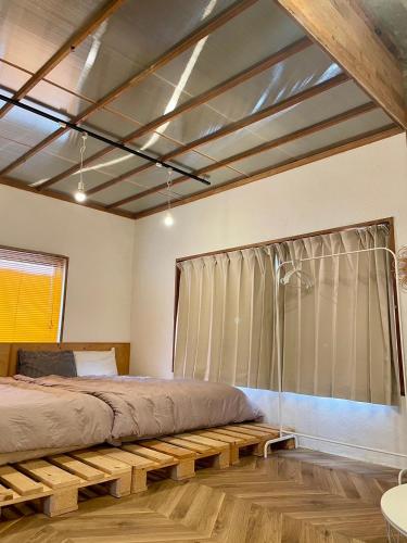 a bedroom with a large bed and a window at お宿イヌとネコと in Shima
