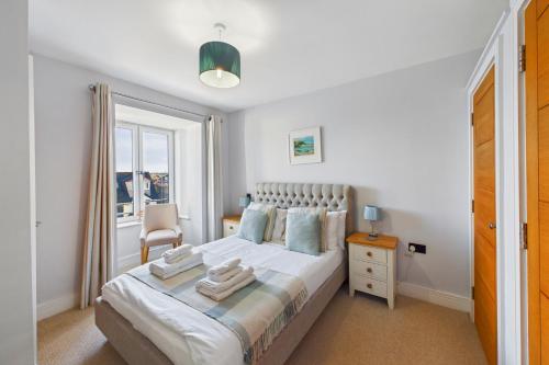 a bedroom with a bed and a chair and a window at Luxury 3-Bed house, Beach 300m, Sleeps 6, Parking in Newquay
