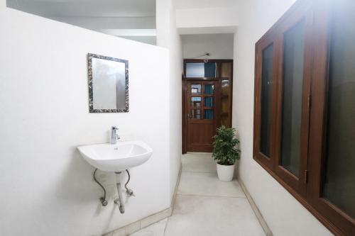 a bathroom with a sink and a mirror on the wall at Mauryan Express I Hotel Malviya Nagar in New Delhi