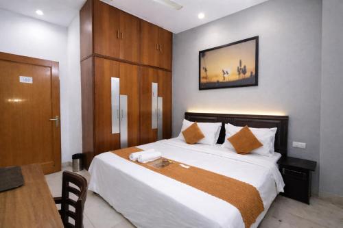 a bedroom with a large bed with a wooden headboard at Mauryan Express I Hotel Malviya Nagar in New Delhi