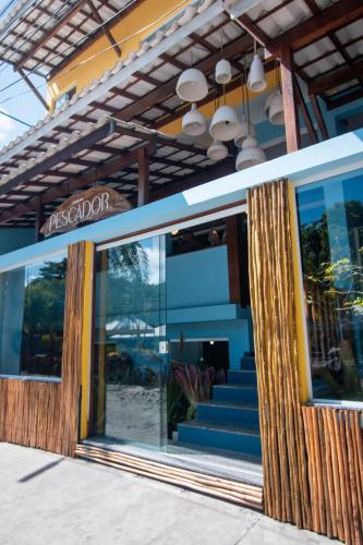 a store front with a glass door and stairs at Hotel do Pescador in Morro de São Paulo