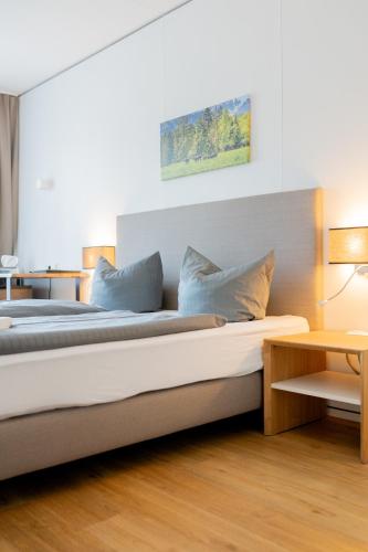 a bed with blue pillows on it in a room at Hotel Casa Maria in Halblech