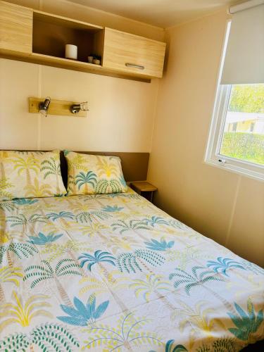a bed in a small room with a window at bungalow le TXOKO in Lit-et-Mixe