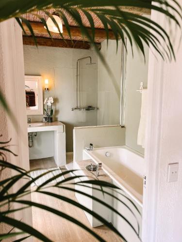ein Badezimmer mit Badewanne und Waschbecken in der Unterkunft Ashbourne Country Escape Hazyview in Hazyview