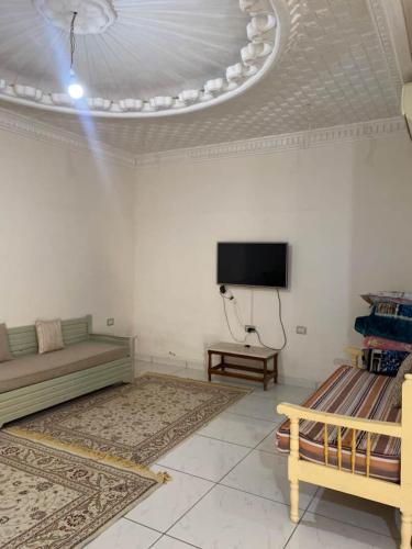 a living room with a couch and a flat screen tv at Dar Tozeur in El Oudiane-Degache