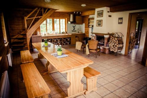 a kitchen and dining room with a wooden table and benches at Atpūtas un sporta komplekss Mednieki - atpūta dabā, pie ezera in Salainis