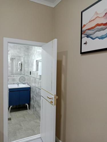 a bathroom with a painting on the wall and a sink at Luna Plaza Hotel in Lunacharskiy Bekati
